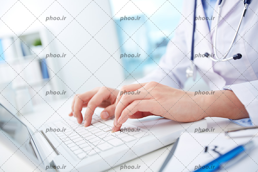 عکس با کیفیت پزشک با روپوش سفید در حال کار کردن با لپ تاپ