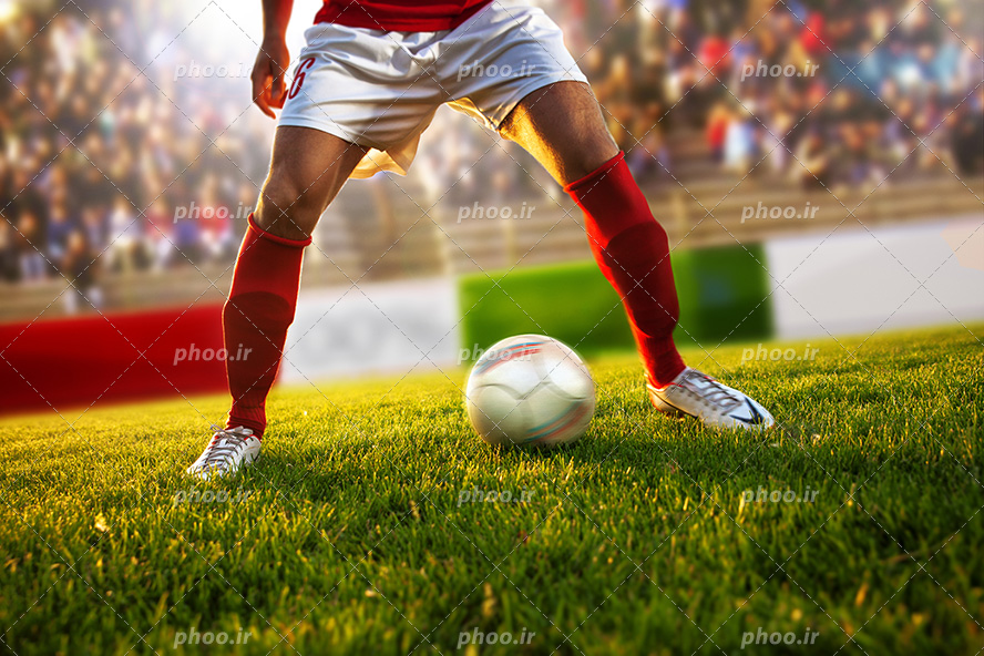 عکس با کیفیت فوتبالیست در زمین چمن و ایستاده پشت توپ و آماده ی شوت کردن