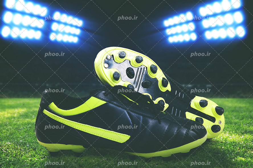 عکس با کیفیت کفش های فوتبالی در زمین ورزشگاه