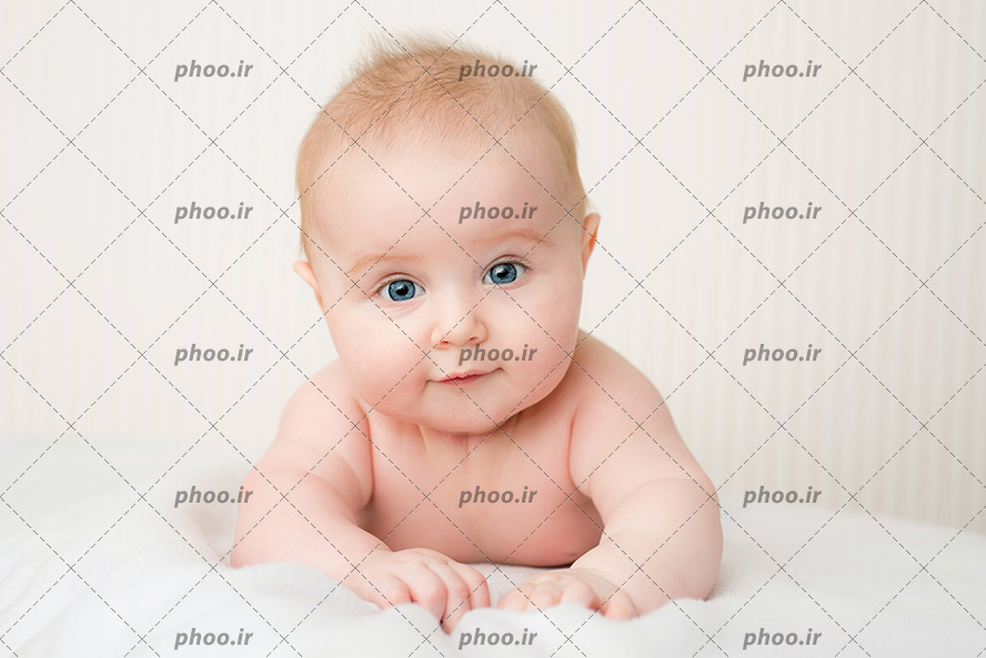 عکس با کیفیت نوزاد با چشم های آبی و موهای بور خوابیده بر روی تخت