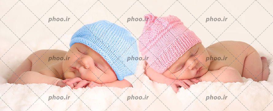 عکس با کیفیت دو نوزاد دختر و پسر در حال خواب با کلاه های بافتنی به رنگ آبی و صورت