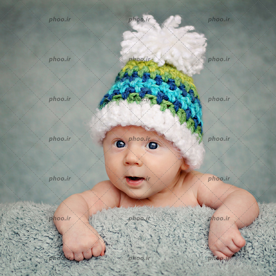 عکس با کیفیت نوزاد بانمک با کلاه بافتنی سبز و چشم های مشکی