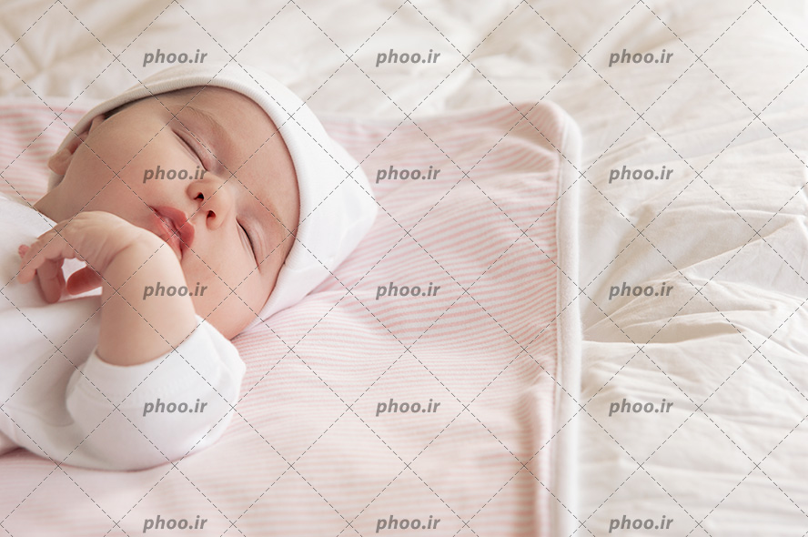 عکس با کیفیت نوزاد در حالت خواب بر روی تخت خواب