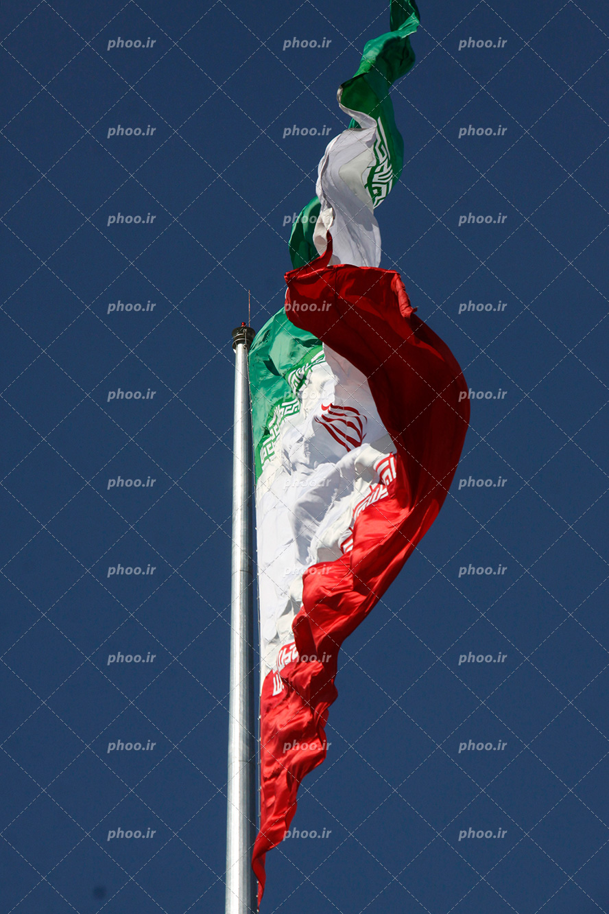 عکس با کیفیت پرچم ایران موج دار به دلیل وزش باد در آسمان آبی