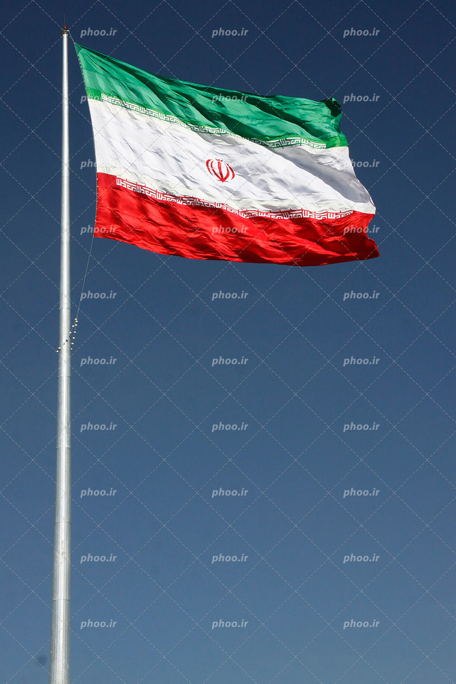 عکس با کیفیت میله نقره ای و پرچم ایران وصل به آن در آسمان در حال تکان خوردن به دلیل وزش باد