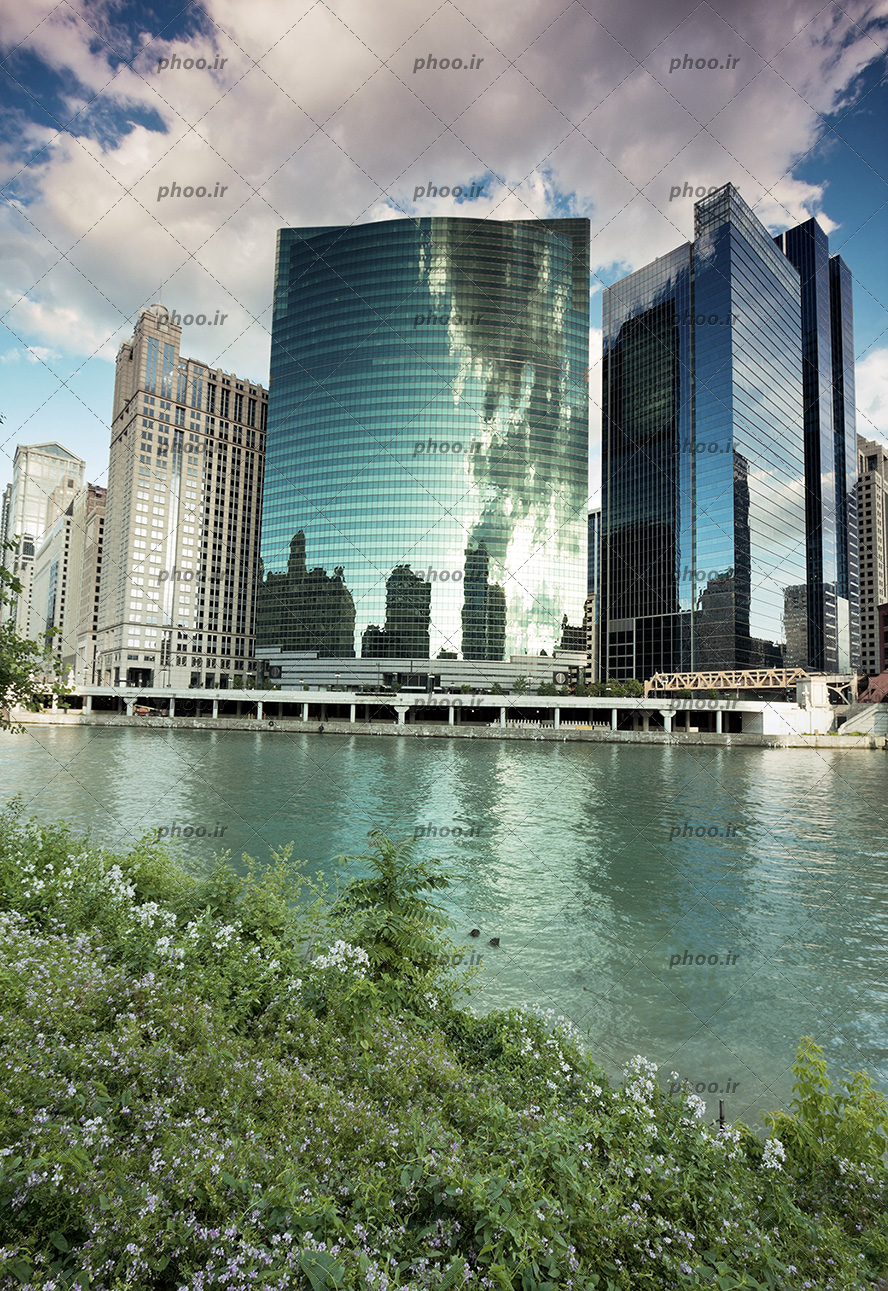 عکس ساختمان های شیشه ای بلند کنار رودخانه