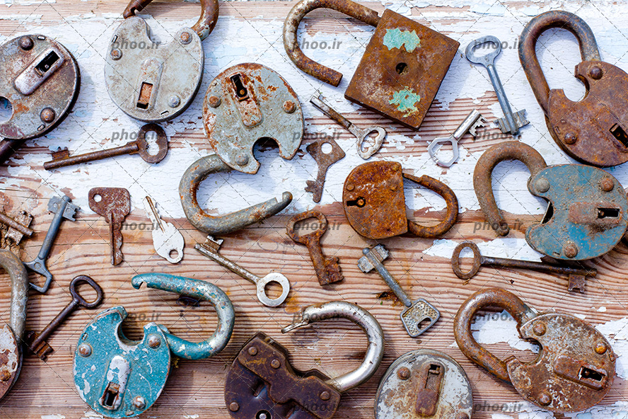 عکس قفل ها و کلید های قدیمی و زنگ زده با زمینه چوبی