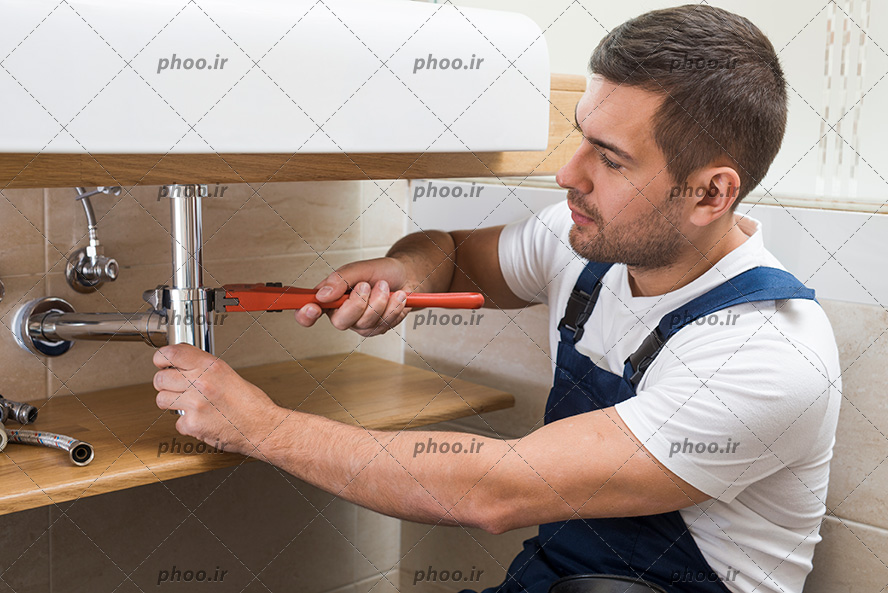 عکس با کیفیت مرد در حال تعمیر کردن لوله های آب