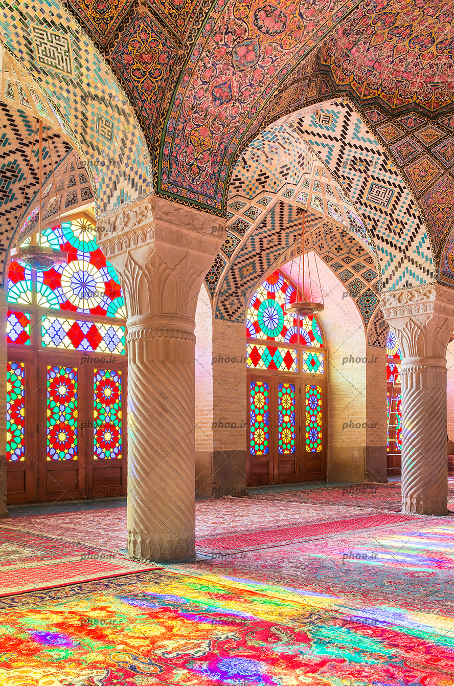 عکس با کیفیت شیشه های رنگارنگ و سقف طراحی شده با نقوش هندسی و خط های اسلیمی و ستون های زیبا در مسجد نصیرالملک شیراز