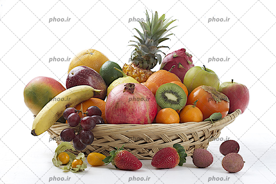 عکس با کیفیت انواع میوه ها موز و انار و نارنگی وکیوی و انگور داخل ظرف حصیری در پس زمینه سفید