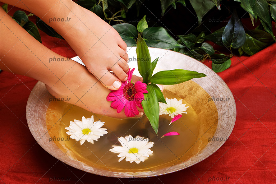 عکس زن در حال مراقبت از پا های خود در آب و گل