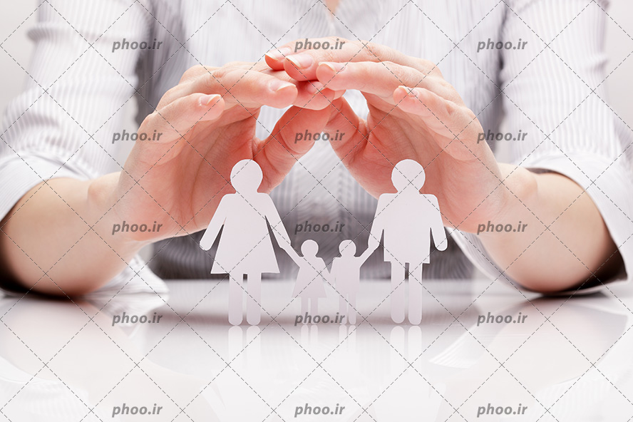 عکس با کیفیت گرفتن هر دو دست به صورت سقف در بالای خانواده ی کاغذی به منظور محافظت از خانواده در برابر حوادث احتمالی