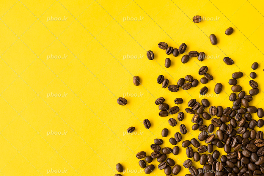 عکس با کیفیت دانه های خوش عطر و کوچک قهوه ها در کنار یکدیگر در پس زمینه زرد