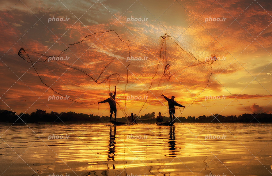 عکس با کیفیت بسیار دیدنی دو ماهیگیر در حال پرت کردن تور بزرگ در آب برای ماهیگیری و آسمان در حال غروب