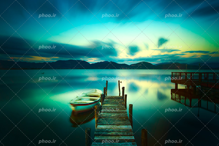 عکس با کیفیت و منحصربفرد پل بر روی دریاچه ی زیبا و رویایی با آسمان سبز آبی و قایق کوچک چوبی شناور بر روی آب