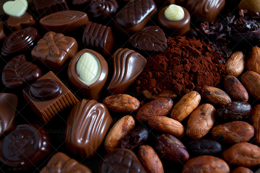 عکس شیرینی شکلاتی با شکل های متفاوت در کنار پودر کاکائو از نمای نزدیک