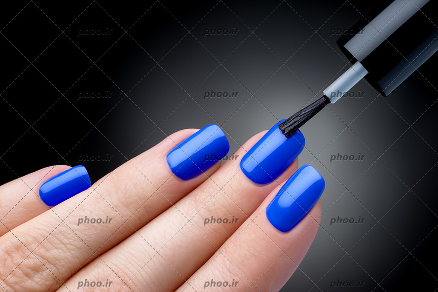 عکس خانم در حال لاک زدن ناخن های خود به رنگ آبی در پس زمینه مشکی