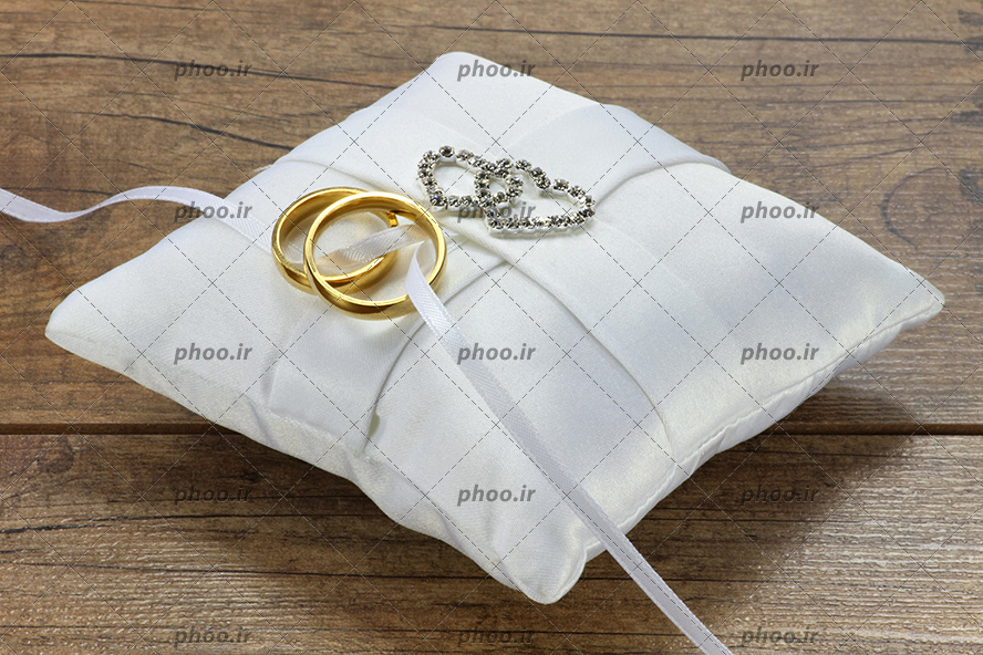 عکس حلقه های ازدواج روی هم و روی پارچه سفید