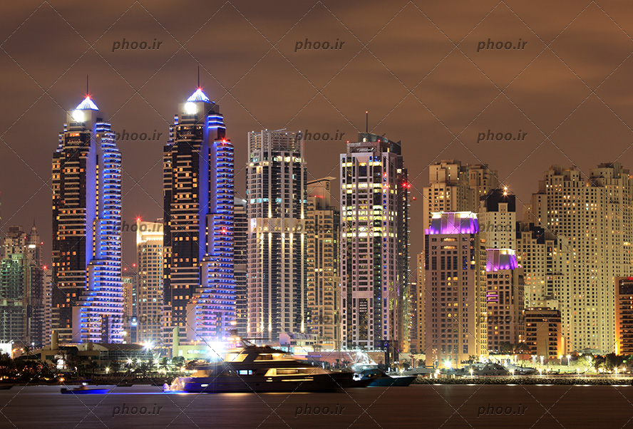 عکس شهر زیبا با برج های نورانی در شب کنار رود یا دریا