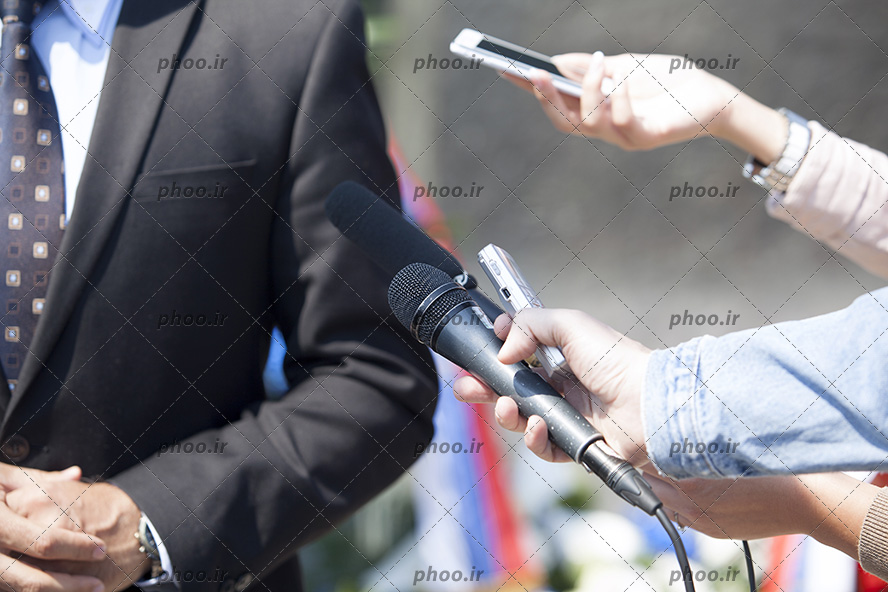 عکس دست خبرنگاران درحال پرسش از مرد دیگر با میکروفون