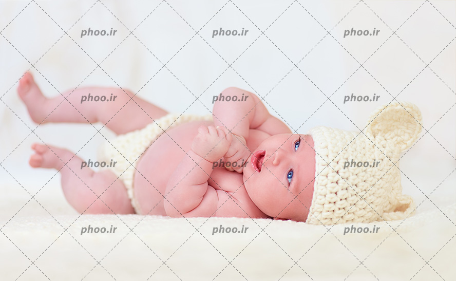 عکس با کیفیت نوزاد خوشگل با چشم های آبی و کلاه به سر در پس زمینه سفید